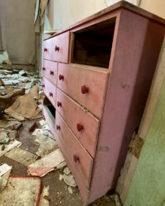 pink dresser in an abandoned farmhouse