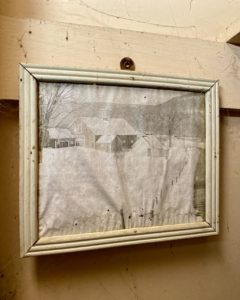 picture hanging in an abandoned farmhouse