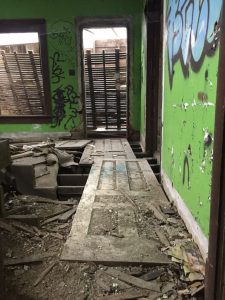 abandoned farm with doors laid across holes in floor