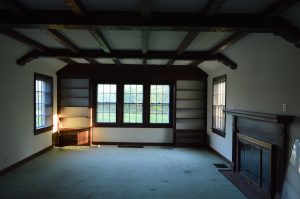lining room with dark wood beams on ceiling and fireplace