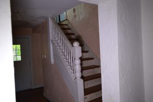 abandoned white stairs inside a farmhouse in ohio