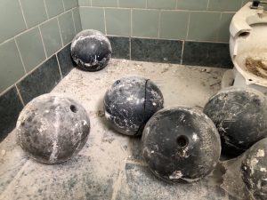 abandoned bowling balls next to toilet