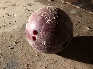 abandoned maroon bowling ball from bowlero lanes