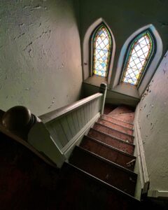 abandoned-church-staircase-two-stained-glass-windows