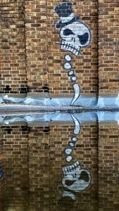 graffiti skeleton top hat reflection in water