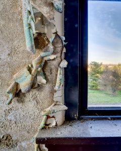 paint-flaking-off-wall-by-window
